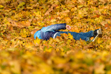 The child plays in fallen leaves