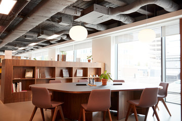 Chairs Around Table In Empty Modern Meeting Area Of Office