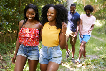 Two black adult couples talking during a walk in a forest