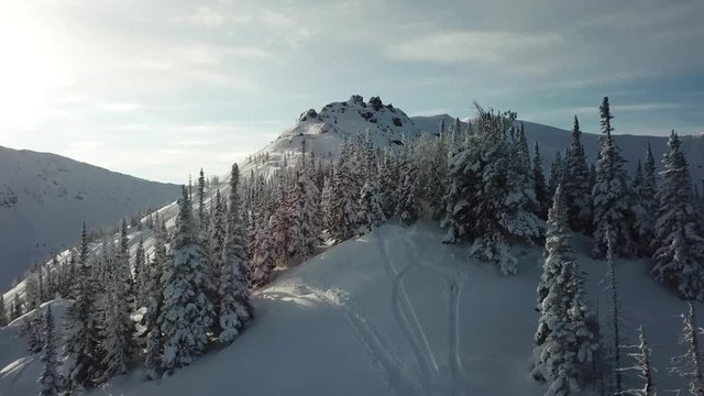 Aerial from drone man skier ski touring in the snowy mountains uphill in a line