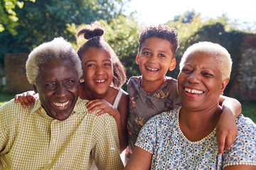Senior black couple sitting outdoors with grandchildren