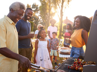 Multi generation black family barbecue, grandad grilling - obrazy, fototapety, plakaty