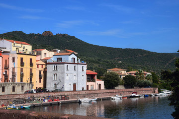 Fototapeta na wymiar Bosa with the river Temo in italy, panoramic view on the boats on the river temo in Bosa in Sardinia including typical colorful Italian houses these are reflected in the river