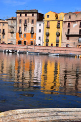 bosa river embankment, panoramic view on the boats on the river temo in Bosa in Sardinia including typical colorful Italian houses these are reflected in the river
