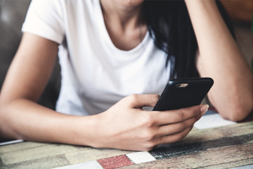  Woman using smartphone in cafe.