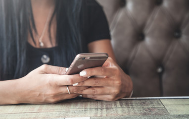  Woman using smartphone in cafe.
