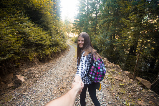 Follow Me. Travel Concept. Back View Of Young Woman With Backpack Outdoors Discovering Jungle Holding Boyfriend Hand.