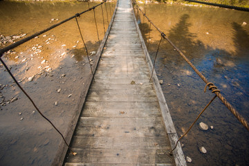 Suspension bridge. Landscape view of long wooden suspension bridge above river. balance