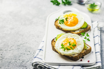 Avocado, cream cheese and fried egg sandwich. Selective focus, space for text.