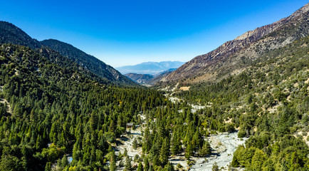 Aerial view of Forest Falls and Oak Creek in the San bernardino Mountains and National Forest with blue sky, green and yellow trees and plants