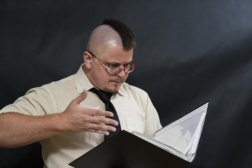Punk standing reads the working folder. White shirt and dark tie. Facial expression attentive,...
