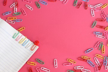 Colorful paper clips isolated on pink background