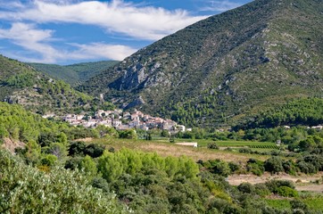 Mediterranean village nested at the feet of wooded hills
