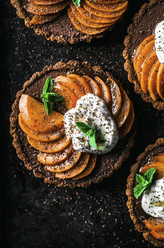 Overhead view of chocolate ganache apricot tarts with almond oat pastry