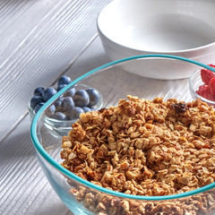 Organic homemade Granola Cereal with oats and fresh berries. Texture oatmeal granola or muesli in aglass bowl on a gray background.