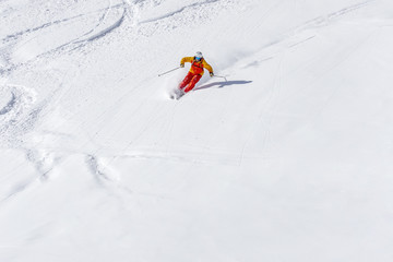 freeride skier skiing downhill, facing forward, white snowy background