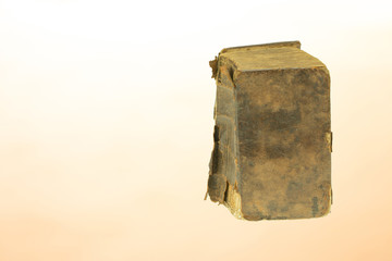 Ancient book. Closeup of old antique book with tattered edge on a light background. Template for your product display montage. Space on left site.