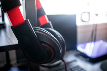 Closeup of Big black and red headphone in home studio on computer desk