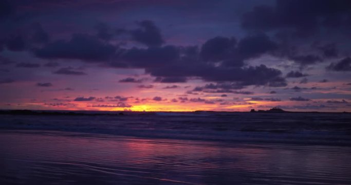 Out of focus background plate of dark purple and orange sunset on the beach in Costa Rica for compositing or keying. Blurred or defocused shot of ocean sun set for green screen composite. 4k