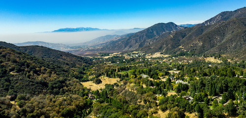 Naklejka na ściany i meble Aerial, drone view of Oak Glen located between the San Bernardino Mountains and Little San Bernardino Mountains with several apple orchards before the Fall color change