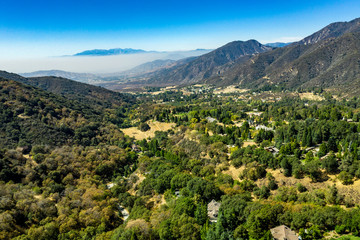 Aerial, drone view of Oak Glen located between the San Bernardino Mountains and Little San Bernardino Mountains with several apple orchards before the Fall color change