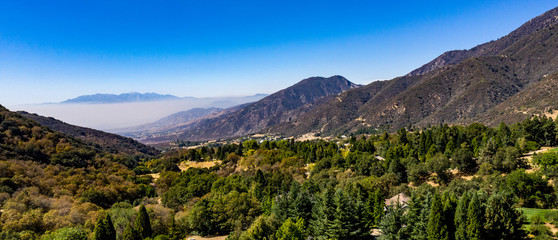 Aerial, drone view of Oak Glen located between the San Bernardino Mountains and Little San Bernardino Mountains with several apple orchards before the Fall color change © joel