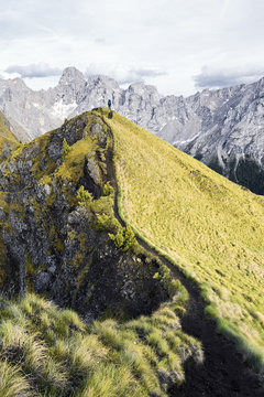 Grass filled mountain with gray mountains in the background