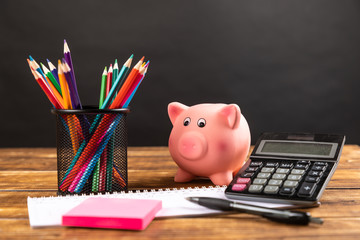 piggy bank with calculator and pencils