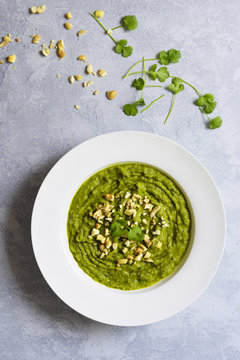 Bowl of broccoli soup with cashew nuts.