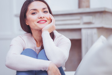 Peaceful. Young charming dreamy woman expressing delightful emotions while propping her chin on...