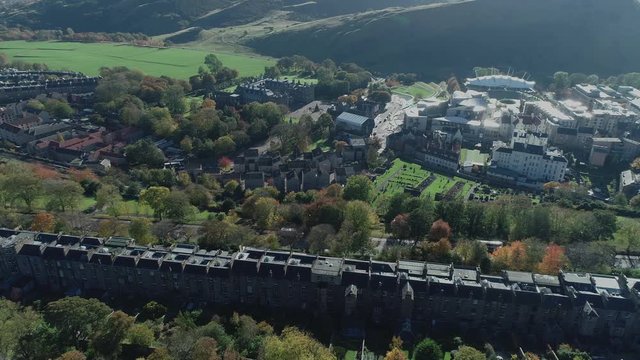 Aerial footage above Calton Hill. Flying right with view to Holyrood Palace and the Scottish Parliament.