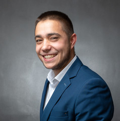 Handsome successfull  businessman in blue suit sitting and showing expressions