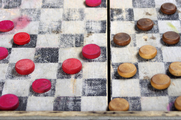 Vintage wooden red and brown checkers on old board game 