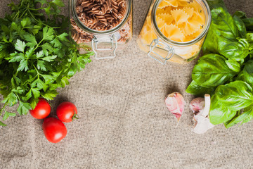 Pasta with garlic, cherry tomato and basil before cooking on a linen cloth in the kitchen