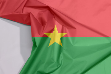 Burkina Faso fabric flag crepe and crease with white space, red and green in yellow star.