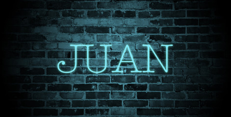 first name Juan in blue neon on brick wall