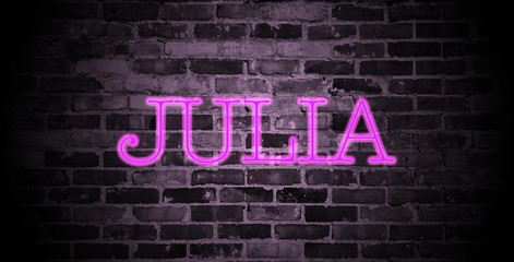 first name Julia in pink neon on brick wall - obrazy, fototapety, plakaty