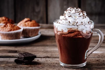 Photo sur Plexiglas Chocolat Boisson au chocolat chaud avec de la crème fouettée dans un verre sur un fond en bois