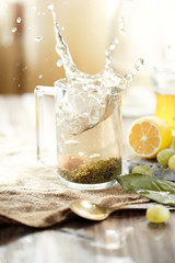 A mug of tea with large splashes, lemon, grapes on the table. Morning concept