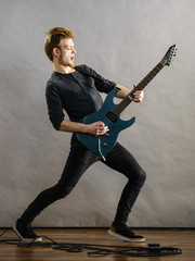 Young man playing electric guitar