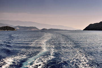 Foamy track of big ship on blue sea