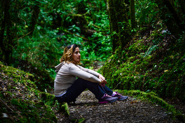 woman sitting on the path of the pensive forest