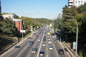 One and the avenues of Kiev, on which cars are traveling at rush hour. In the distance you can see the Monument, a symbol of victory in the Second World War.