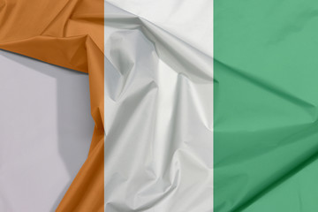 Ivory Coast fabric flag crepe and crease with white space, a vertical tricolor of orange, white and green.