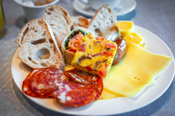 Plate with continental breakfast on the table