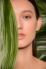 Fototapeta premium Beautiful brunette woman closeup with plants