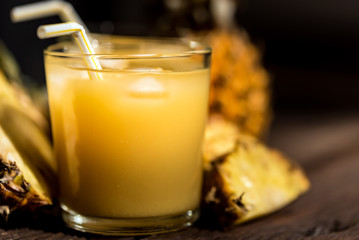 Pineapple juice and slice placed on a wooden table