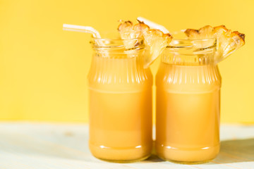 Pineapple juice and slice placed on a wooden table