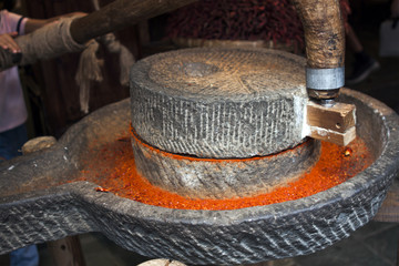 Grinding Dried Red Chillies in a stone Mill.