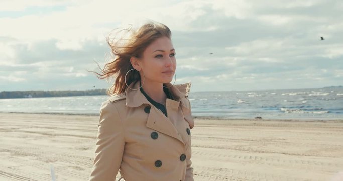 Girl walking on the beach enjoying the warm autumn